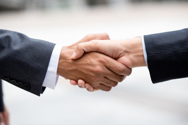 Closed up hands of business partners making firm handshake after meeting for merger and acquisition concept